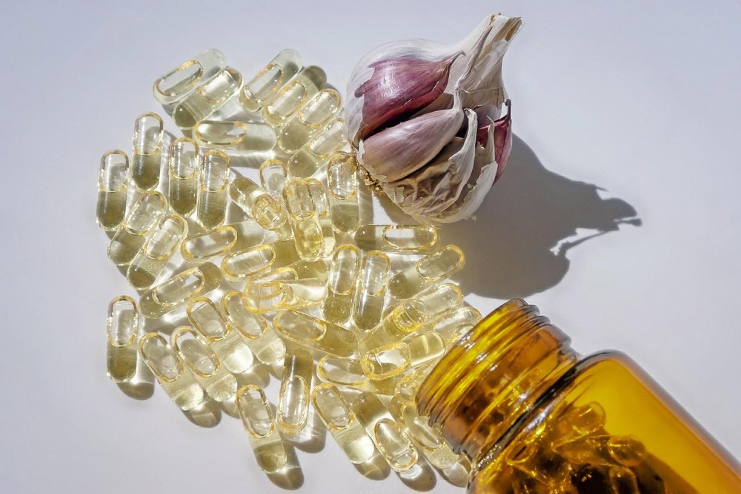 Omega-3 capsules, garlic and oil representing dietary support for fatty liver disease