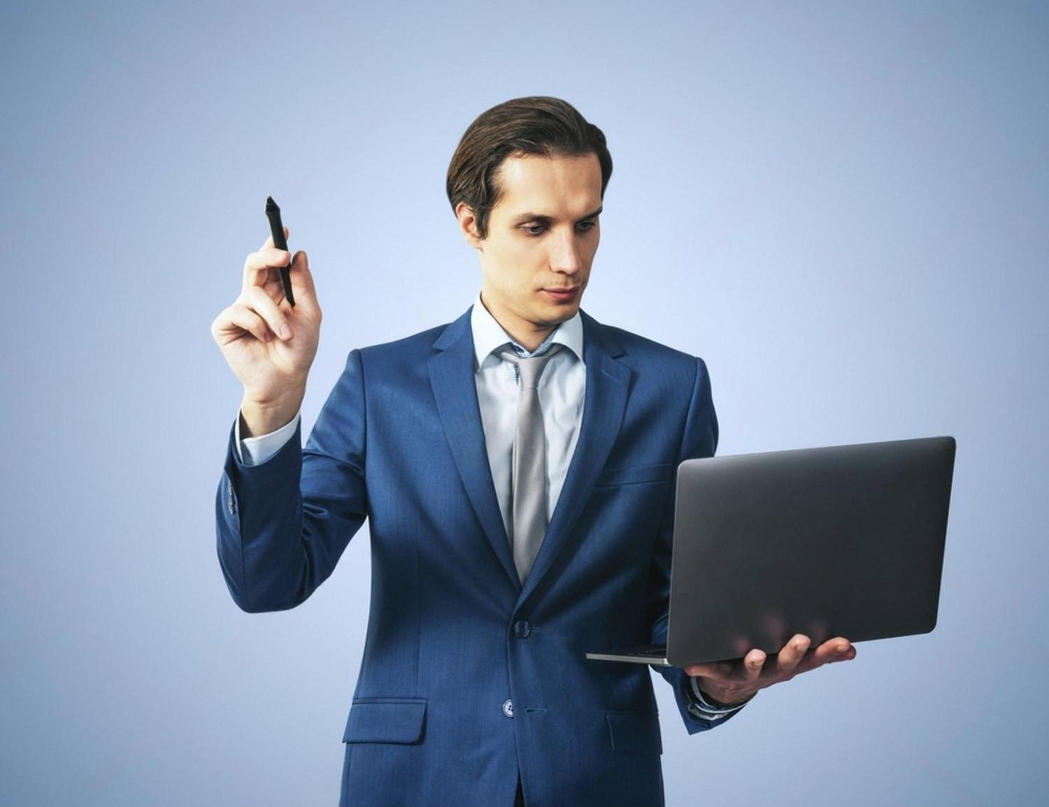 Businessman in a blue suit reviewing rental directory options on a laptop
